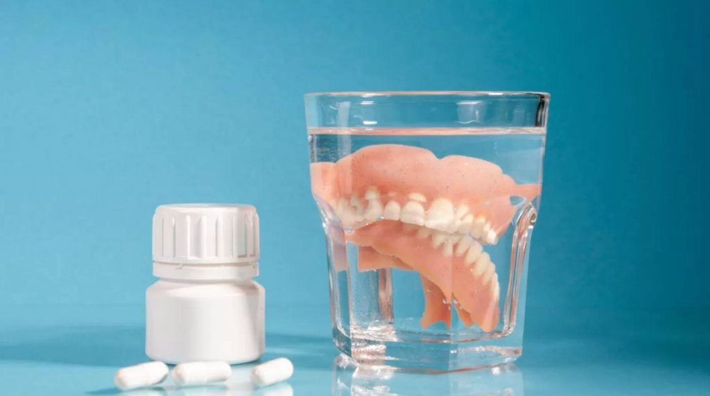Dentadura postiza en vaso de cristal